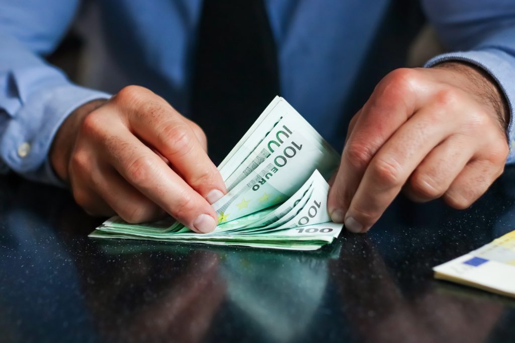 Manos con dinero, euros, contando.
